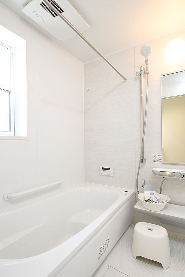 【浴室】白を基調とした清潔感あふれる空間。存分にくつろげるよう設計されたバスタブで、１日の疲れをとってリセットしましょう。雨の日や夜の洗濯にも重宝する浴室乾燥暖房機付きです。（81号棟）