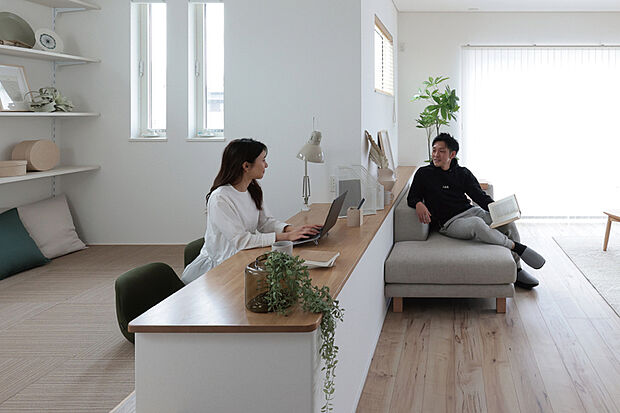 【【STYLE 2 / STAGE LIVING】】自分時間を心地よく楽しめる小上がりのステージと、空間全体に広がる化粧梁が印象的なリビング。キッチン天井には、やわらかな光を広げる間接照明を採用し、上質でホテルライクな雰囲気を演出します。