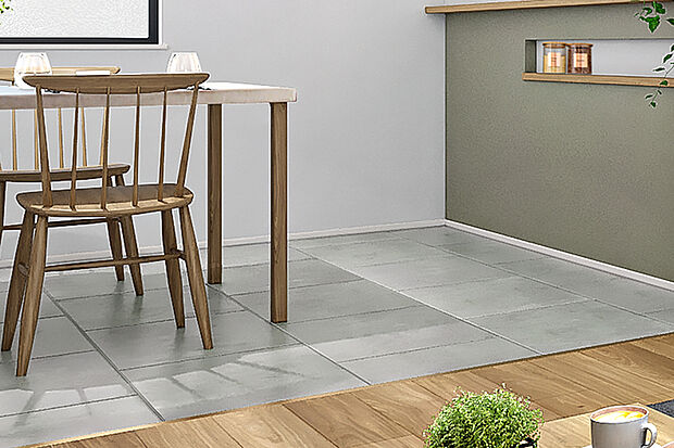 【【コンカーボ】】抗菌加工を施したSIAA認証取得の非木質意匠のフロア。無機質な印象を持つモルタルの素材感を表現したフロアを採用しました。ワイドサイズが非日常な空間を演出しています。※ダイニング・キッチン部分に採用。