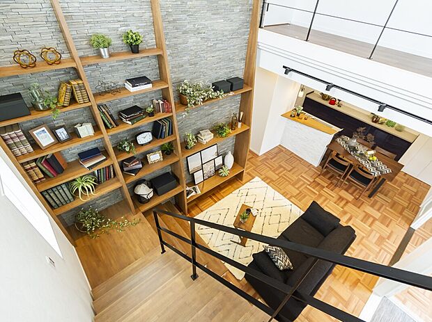 【当社施工例】リビングの壁一面にギャラリーにもなるシェルフを設けたプラン。本棚としてお気に入りの本を並べたり、趣味の小物を飾ってインテリアを楽しんだり。好きなものに囲まれた暮らしが始まります。