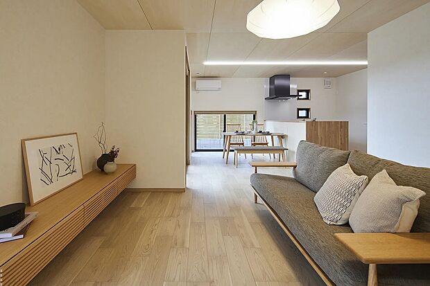 【リビング】リビングは地窓でプライバシーを守りつつ外の木々を眺められる設計に。照明は間接光とペンダントを中心に最小限のダウンライトで、落ち着いた空間を演出します。