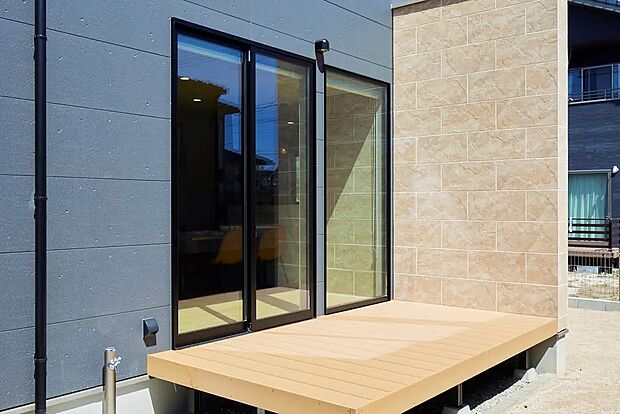 【ウッドデッキ】リビングからフラットに渡れるウッドデッキ。壁も室内から同じ素材で統一することで、空間の繋がりを演出しています。