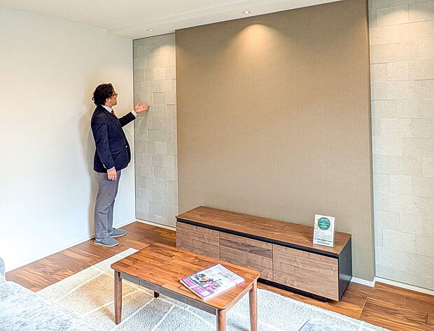 ダウンライトに照らされたアクセントウォールとアクセントクロスが、上質さを演出するLDK空間。（2号棟）