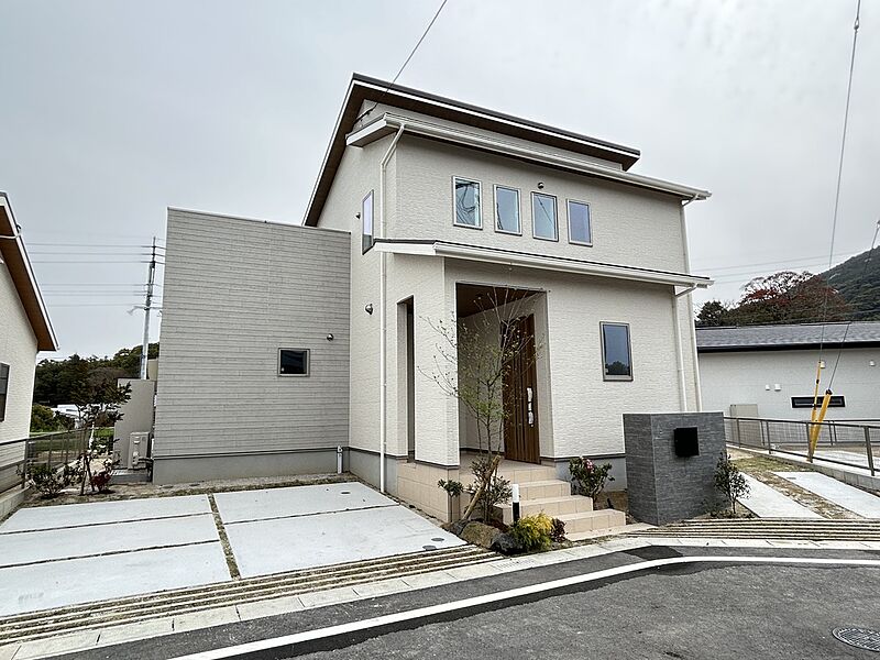 北側から撮影した73号地の外観です。駐車3台可能の2階建て住宅で、通りから見えない南庭にタイル張りテラスが配置されています。差し掛け（段違い）屋根を採用することで太陽光設置面積を最大化しました。