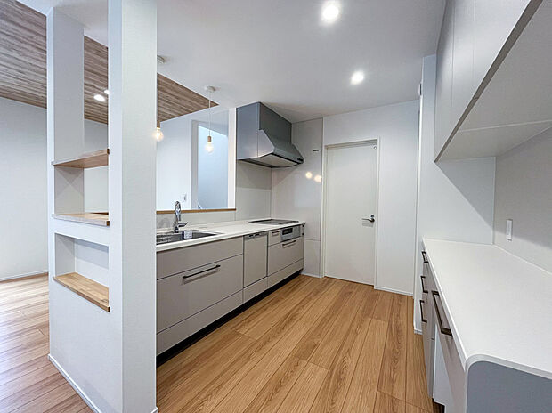 【いつでも家族を見守れる、開放的なキッチン】ニッチや棚で仕切られたキッチンとダイニング。リビング側からは手元が見えないので、少し散らかっていても気になりません◎扉の向こうは洗面室になっています。