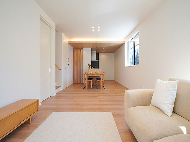 【リビングダイニング】約19帖のLDKに大きな窓から光が広がり、下がり天井と高い天井が立体的な奥行きをつくる空間。間接照明とダウンライトが陰影を整え、家族が自然と集まる、上質で開放的なリビング