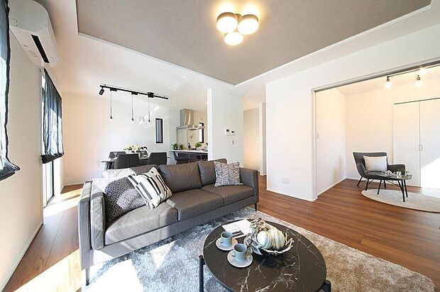 【施工例/LDK】
シンプルかつモダンな内装デザインが魅力的なLDK。陽光が降り注ぐ明るい空間です。隣接する洋室は、引き戸を開放し、一体利用も可能◎用途に応じてご活用いただけます。