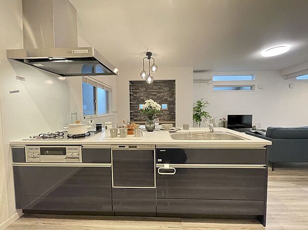 【キッチン/9号地モデルハウス】キッチンから見たリビングの様子です。前面の壁をすべて取り払うことで、とても開放的な空間となりました。コンロ前には油跳ねを防ぐついたてがあるので、安心してお料理ができます。