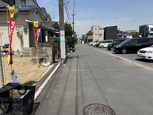 【【前面道路含む現地写真】】東側の前面道路をはさんで向かい側は、現況駐車場です。圧迫感がなく開放的な立地です。