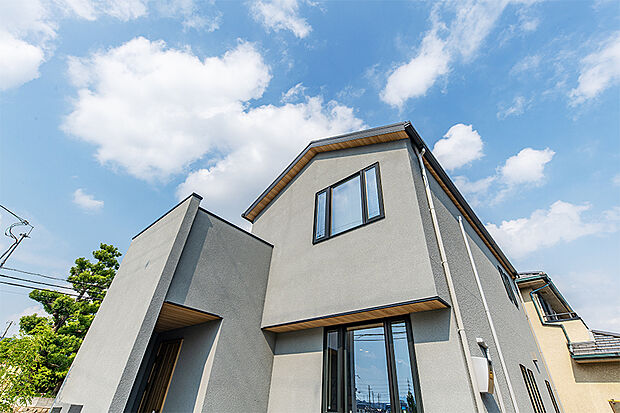 【近くで最終公開中のモデルハウス外観写真】
分譲地近くで最終公開している、青空との調和が美しいグレーのオシャレなモデルハウス。南向きの窓からは家中に光が広がり爽快な邸宅に。