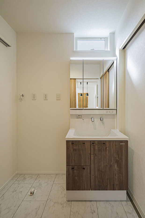 【【洗面室/当社施工例】】木目調の洗面化粧台は、家具のようなお洒落な雰囲気。ボウル下の収納スペースに化粧品やタオルなどをすっきりと収納可能です。窓があり、自然光を採り込めます。