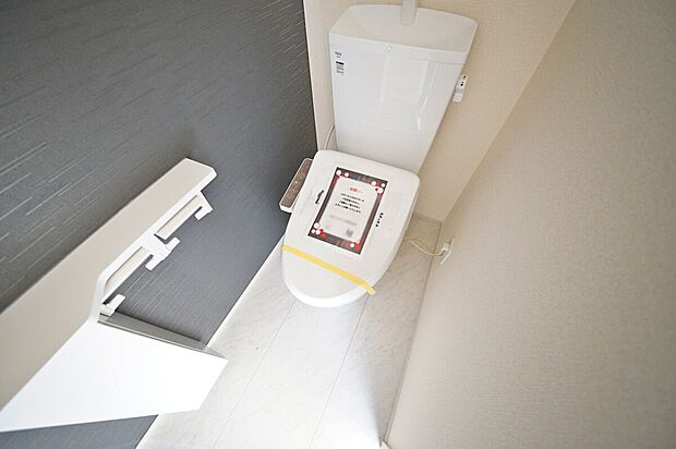 【トイレ】ダークカラーのアクセントクロスに彩られたトイレ、温水洗浄機能付きです