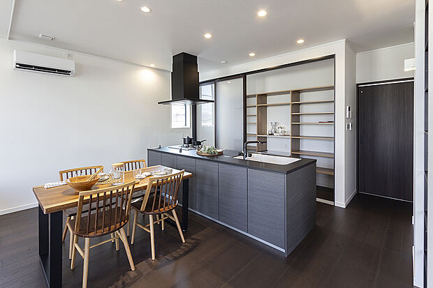 【【2階約17.5帖LDK/A号地モデルハウス】】存在感が光るオープンスタイルのアイランドキッチン。背面の収納は天井までの大容量×抜け感のあるガラス扉により洗練された印象です。背面の扉からランドリールームやバルコニーへつながり、スムーズな家事動線に。