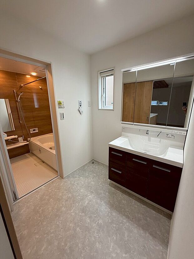 【4号地洗面脱衣室】4号地洗面脱衣室(2025年7月)撮影
洗面化粧台には三面鏡とシャワー付きで、朝の支度がスムーズに行えます。キッチンとの動線もよく、忙しい時にも効率良く家事ができます。