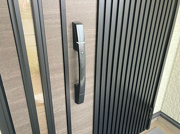【玄関】玄関ドアには電子キーを採用。両手が塞がっていてもハンドルのボタンを押すだけで施錠・解錠が可能です。車と同じ感覚でお家も施錠できます。また、登録式なので家族が増えても安心です（画像はイメージ）。