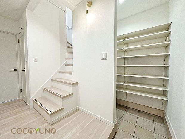 【玄関】当社施工例:開放感のある階段を採用した、広がりを感じる玄関。