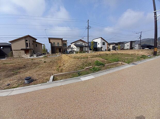 【東側境界標付近からの現地外観写真(14-6号地)】周囲は低層住宅街で、ゆったりとした前面道路のため、開放感を感じられるのが魅力の一つ。理想の住まいを計画しやすい区域です。