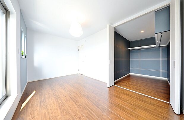 【【施工例】ウォークインクローゼット】チェック柄のアクセントクロスが目を引く、上品なウォークインクローゼット。衣類の収納だけでなく、身支度の時間も心地よくしてくれます。