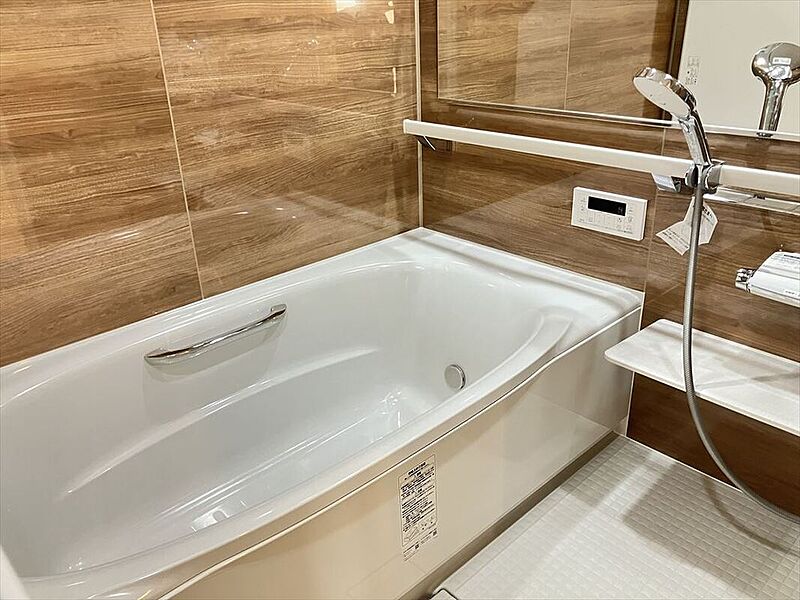 【浴室】
木目調のアクセントパネルが採用された、落ち着きのある浴室です。フレーム付きワイドミラーが備わっているので、奥行きが感じられ、より広い空間を演出します。