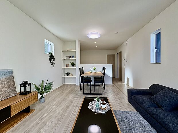 【【LDK】】約15.0帖のLDK。3面採光で1日中明るく気持ち良い風が舞い込みます。キッチン前に可動棚が備わっており、小物類を置くスペースとして活用できます。