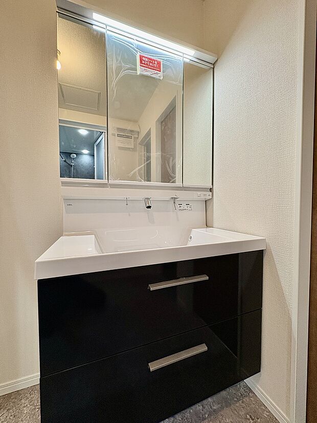 【【洗面化粧台/1号棟】】身支度を整えやすい三面鏡付き洗面化粧台が採用されています。水栓は上から吐水するタイプで水垢が溜まりにくく、お手入れをスムーズに行えます。