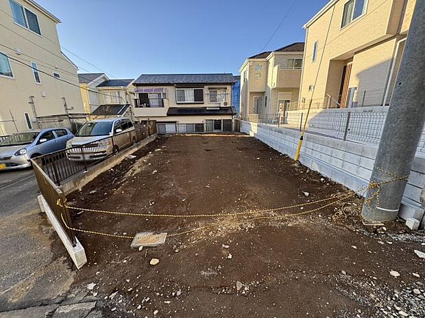 【現地写真】南東側道路×隣地駐車場に面した開放的なポジション。周囲の視線を遮りつつ、室内にたっぷりと陽光を取り込める設計。陽光が降り注ぐ明るい新生活を。（2026年3月撮影）