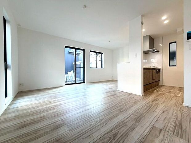 【【リビング】】南向きの窓から陽光が降り注ぐ、明るく開放的な15帖LDK!ホワイトを基調とした内装と温かみのある木目調フロアが、家族の団欒を優しく包み込む心地よい住空間を演出します。