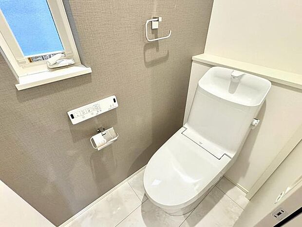 【トイレ】壁一面に施したアクセントクロスが、シンプルになりがちなトイレをモダンで洗練された印象に仕立てます。日常のふとした瞬間に、デザインのゆとりを感じられる住まいです。