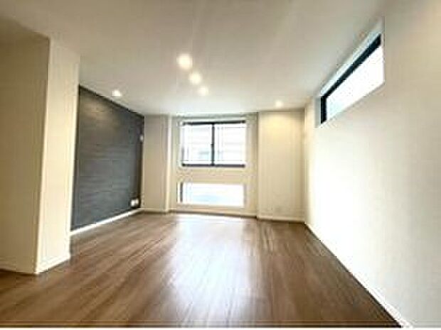 【※イメージ写真】大きな窓から光が差し込む明るい居室。壁にはシックなアクセントクロスと木目調の天井を採用し、洗練された空間を演出します。ゆったりとしたプライベートタイムをお過ごしください。