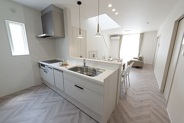 【【1階キッチン/C’号地モデルハウス】】リビング収納の扉やリビングドアと統一感のあるキッチン。背面にパントリーを設け、調理家電や食材などがスッキリと収まり、調理スペースが広々。リビングやダイニングへ視界が広がり、調理中もご家族とのコミュニケーションが弾みます。