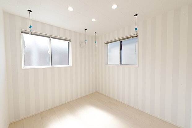 【【2階約4.5帖サンルーム/D号地】】南向きに位置しており、陽光がたっぷり注ぎ込む明るい空間。ストライプ柄の壁紙が目をひきます。洗濯物を季節や天候に左右されずに干すことができる室内物干しを2箇所設けました。