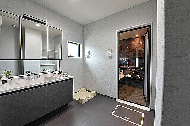 【【当社施工例】】玄関から土間収納を抜けて洗面室へ。帰宅後、手を洗ってからリビングやキッチンに向かうことができます。家事がはかどるゆとりある広さを確保。タオルや洗剤のストック置場に便利な収納も備えています。