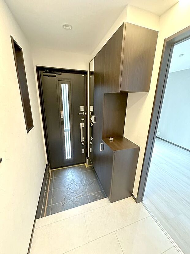 【【アーバンポート施工例】玄関】御家族皆様の「いってきます」「ただいま」の声がこだまする、清潔感溢れる玄関スペースです。大容量シューズボックスがありますのでいつ来客が来てもスッキリとした空間に。