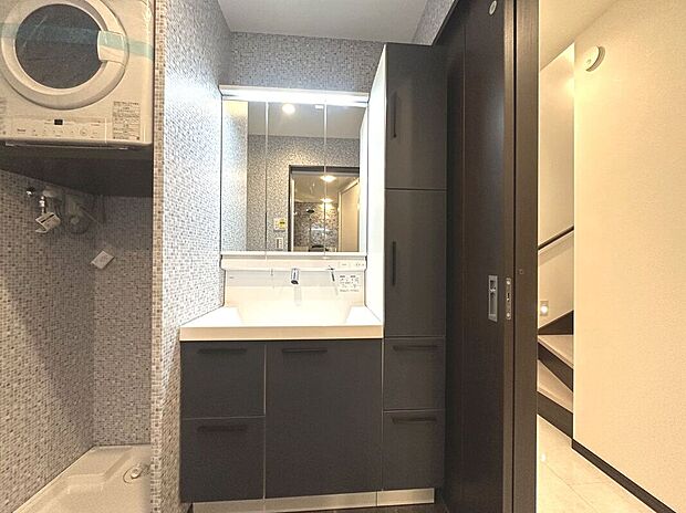 【洗面化粧台【Ａ号棟・2025年12月撮影】】大きな三面鏡と併せてリネン類等、たっぷりしまえるサイドキャビネットを備えています。