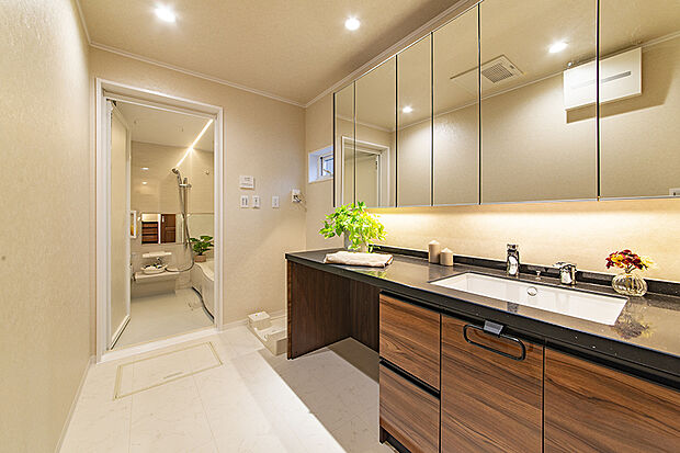 【【当社施工例／洗面室・浴室】】清潔感あふれるベージュを基調とした一室。洗面台にブラックを取り入れ、重厚感のある空間に仕上げています。