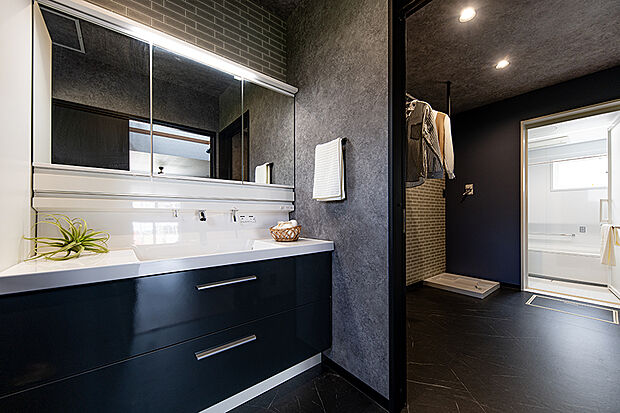 【【当社施工例／洗面室・脱衣室】】石目調のクロスがシックな雰囲気を演出する洗面室。ホワイトを基調とした洗面台が、空間にほどよいメリハリをもたらします。