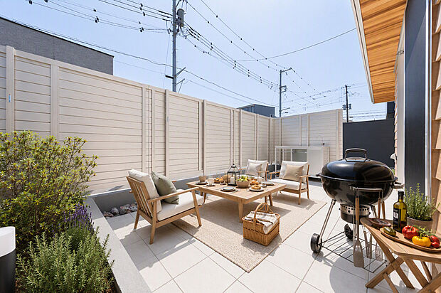 【2号棟】外からの視線が気にならないテラス。屋外シンクで野菜を洗って週末はBBQ。テラスで遊ぶ子どもをLDKから見守れて安心です。イメージ（AI画像）