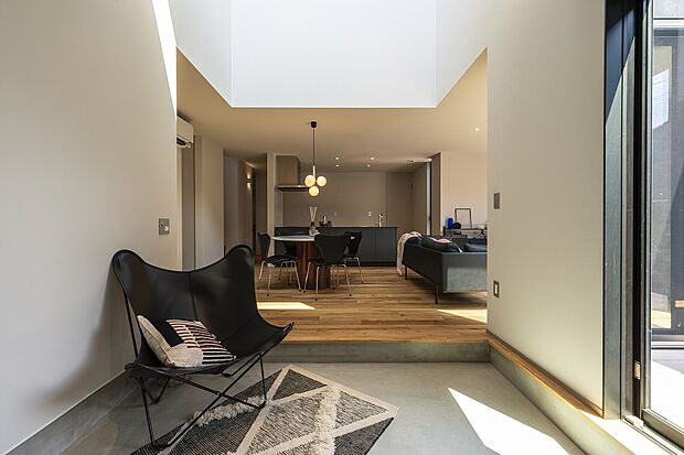 【1号棟】ガレージが土間を介してLDK、ウッドデッキ、土間収納と繋がる間取り。天井までのドアや窓を採用し、無駄なラインをそぎ落とすことでスッキリと広い空間に仕上げました。