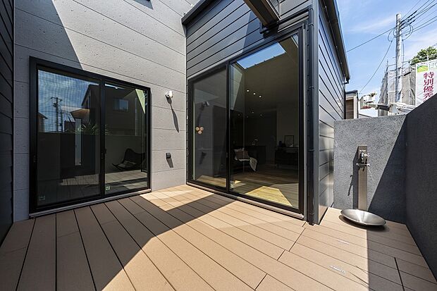 【1号棟】外からの視線が気にならないプライベートなウッドデッキ。リビングは横幅の広い窓を設置しているため、BBQの準備など出入りがスムーズ。