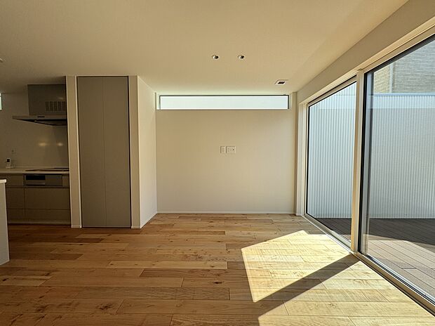 【-】ウッドデッキは外壁と同じ白いガルバリウムで囲まれ、通りからの視線が気にならない設計です。また、横幅の広い窓を採用。物や人の出入りがしやすいです。