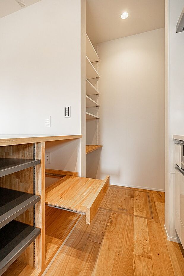 【-】作業台兼ダイニングテーブルの下は、表からは見えない収納スペース。oneアクションで食器や調理器具を取り出せて作業が捗ります。また、奥には冷蔵庫や電子レンジを置けるパントリーも。