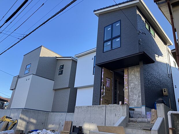 【AB棟外観】周辺の街並みと調和する、お洒落な外観デザイン。アースカラーの優しい色合いが青空に映えます。全棟長期優良住宅認定物件です。