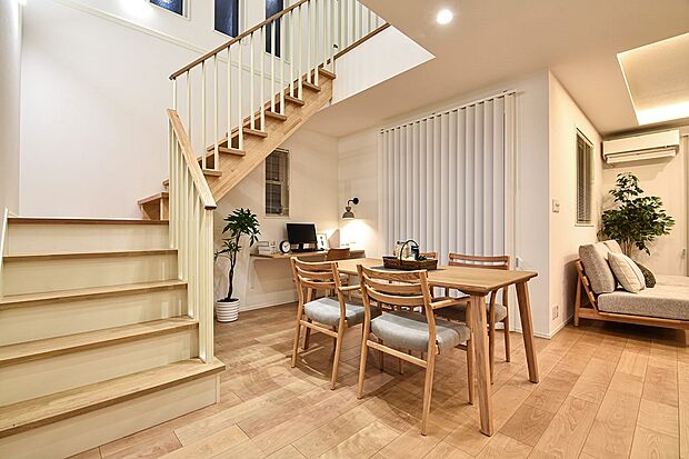 【吹き抜けダイニング】デザイン手すりの階段と美しい梁が映える、開放感あふれる吹抜けLDK。（12号棟夕景｜2026年1月撮影）