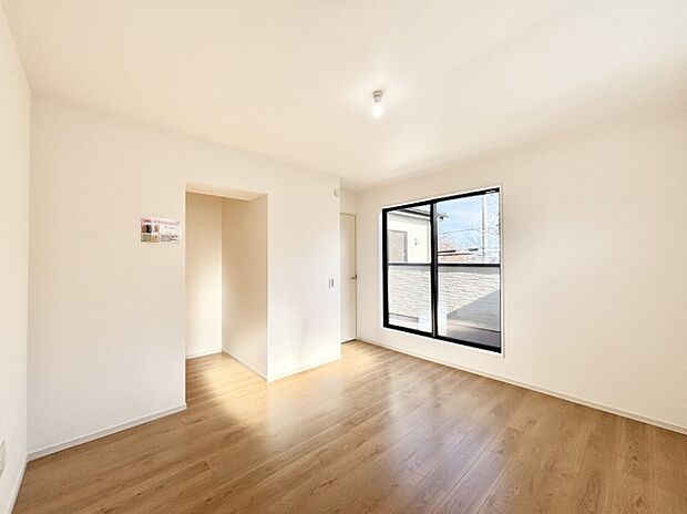 ウォークインクローゼット付きの洋室。バルコニーから入る明るい陽光が部屋全体を明るく照らします。