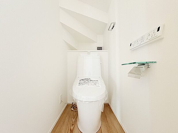 【内観】【トイレ】類似内観仕様  階段下の空間を有効活用したトイレ。温水洗浄便座付きで快適性も確保し、清潔感ある内装で毎日気持ちよく使える設計です。