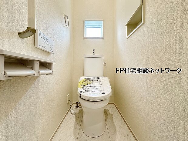 【トイレ】【トイレ│1階】小窓付きで明るく清潔感のあるトイレ空間。温水洗浄便座や収納棚を備え、毎日快適に使えるよう細部まで配慮された設計です。