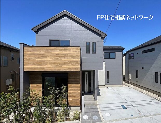 【現地外観写真】【外観】 スタイリッシュなグレーの外壁に、木目調のアクセントが映えるモダンな一邸。外構も美しく仕上げられ、植栽が彩りを添えます。12.jpgのデザイン性の高い住まいで、新しい生活を。
