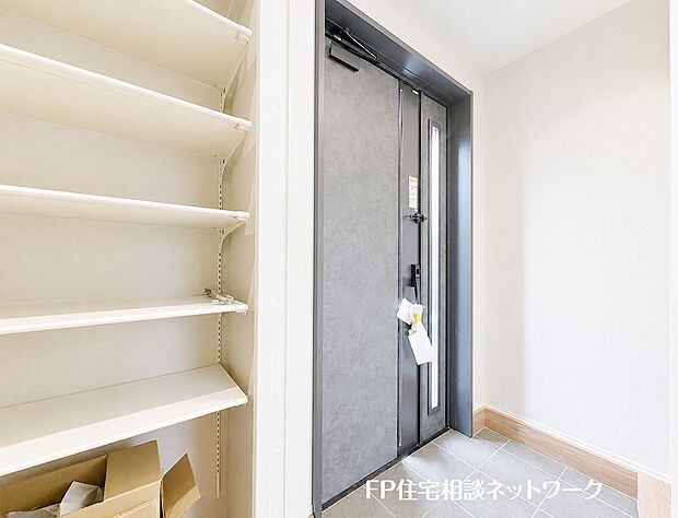 【玄関】モダンで重厚感のある玄関ドアがお出迎えします。壁一面に設けられた大容量のシューズボックスは便利な可動棚となっており、家族全員の靴をすっきりと整理整頓できます。
