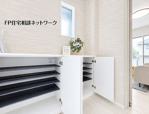 【玄関】清潔感のある白い下駄箱を設置した玄関。オープンスペースの棚板があり、お気に入りの靴を並べることができます。小窓から差し込む光が、明るい空間を演出します。