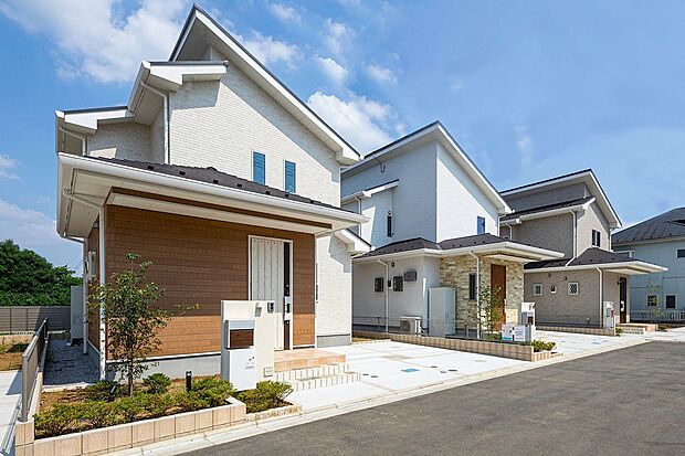 【 住協建設の施工例 】青空に映える、白と木目のコントラスト。 素材感のある木目調パネルがアクセントに。明るく開放感あふれるデザインが、日々の暮らしを軽やかに彩ります。